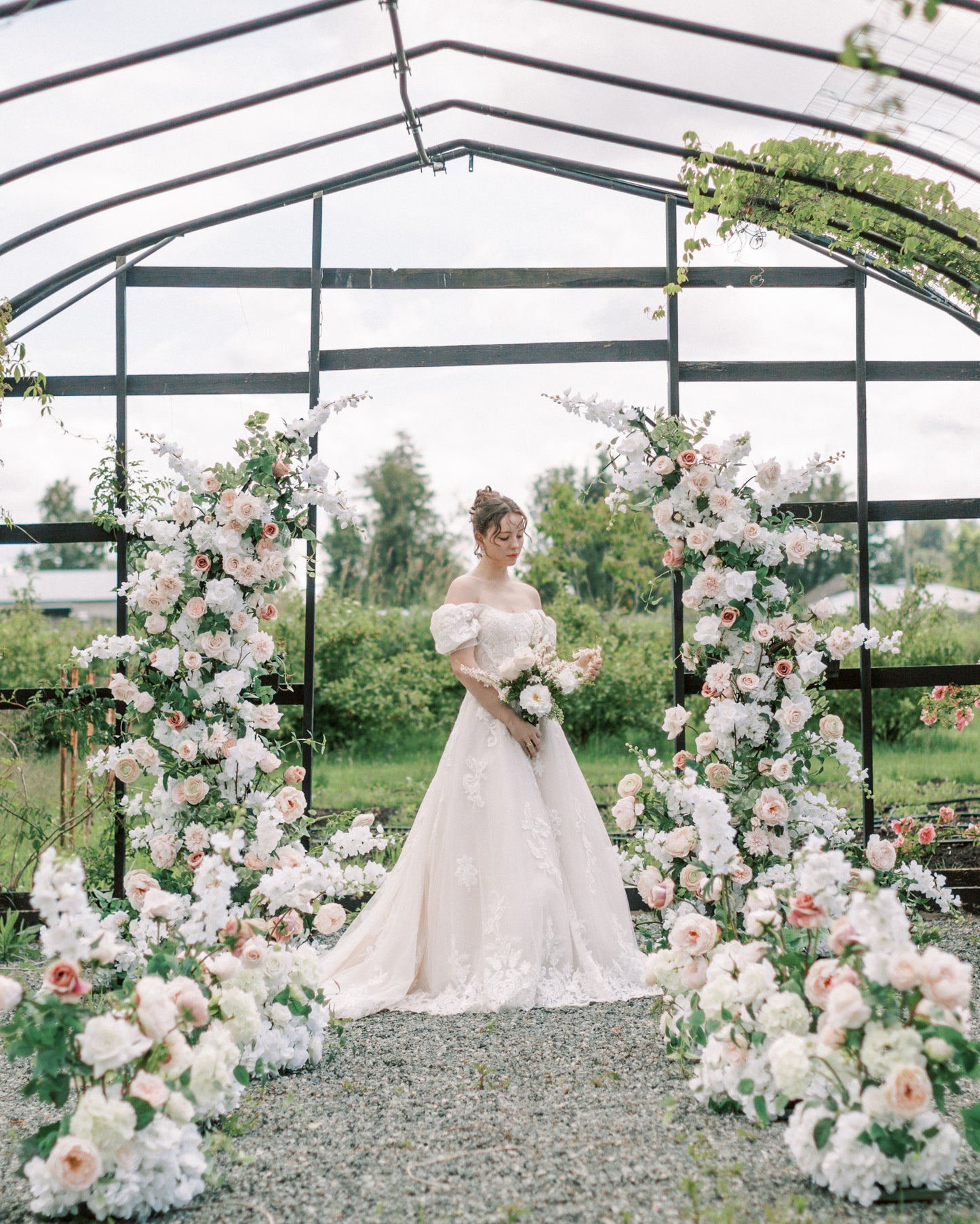 bride with blush arch and aisle flowers